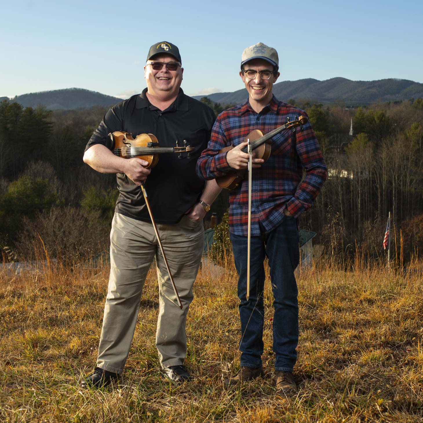 Eddie Bond and Andrew Small stand together with their instruments on a hill in Virginia.