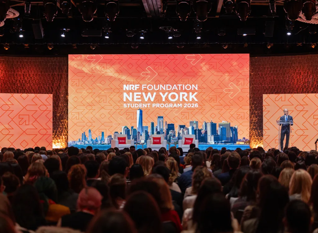Large crowd at NRF Foundation New York Student Program 2026 sitting in front of speaker standing on large stage.