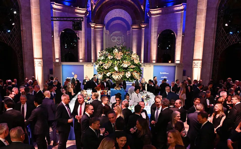 Guests enjoying GLAD 2025 in beautiful room with blue lights and tall ceilings